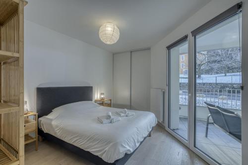een slaapkamer met een bed en een groot raam bij View Point Semnoz in Annecy