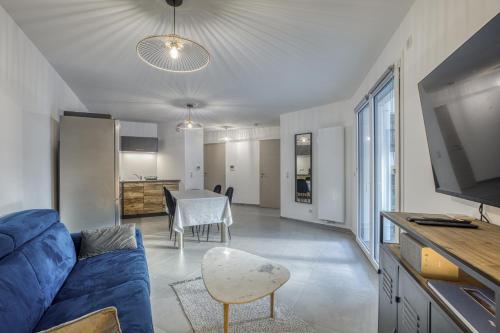 un salon avec un canapé bleu et une table dans l'établissement View Point Semnoz, à Annecy