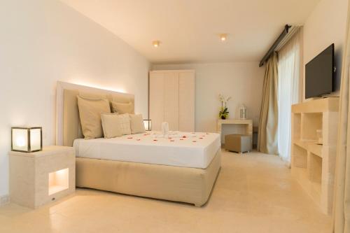 a white bedroom with a large bed and a television at HOTEL BARONE DI MARE in Torre dell'Orso