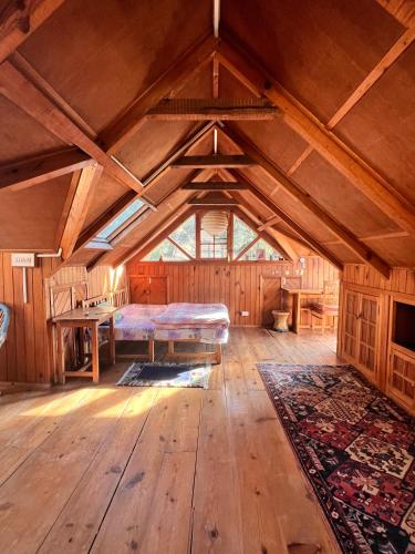 a large room with a bed and a wooden floor at Naddi Castle in McLeod Ganj