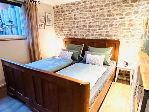 2 Betten in einem Schlafzimmer mit Ziegelwand in der Unterkunft Ferienwohnung Palatina in Heuchelheim-Klingen