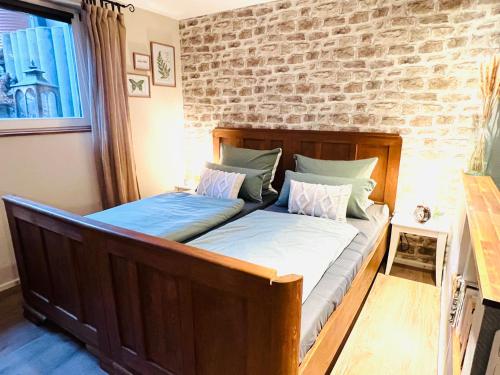 two beds in a bedroom with a brick wall at Ferienwohnung Palatina in Heuchelheim-Klingen