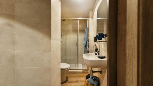 a bathroom with a white toilet and a sink at Livensa Living Studios San Sebastián in San Sebastián