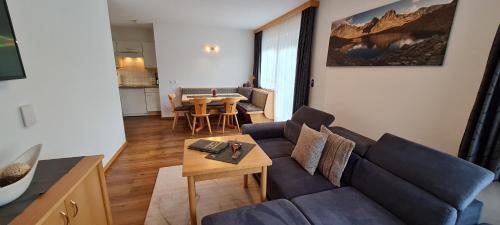 a living room with a blue couch and a table at Gästehaus Walch in Fendels