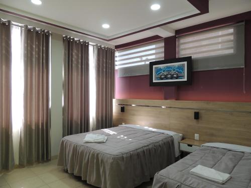 Habitación de hotel con 2 camas y TV en RESIDENCIAL CARMANI, en Tacna