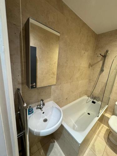 a bathroom with a sink and a tub and a toilet at Property minutes from Hammersmith and Kensington 2 in London