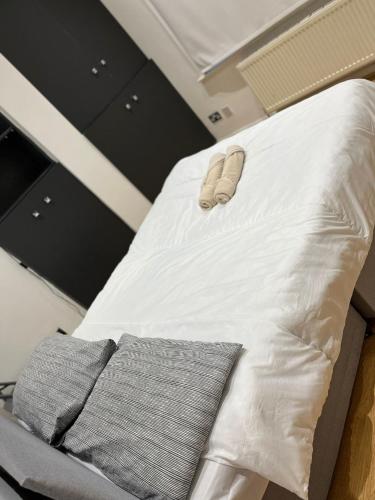 a bed with a pair of slippers on top of it at Property minutes from Hammersmith and Kensington 2 in London