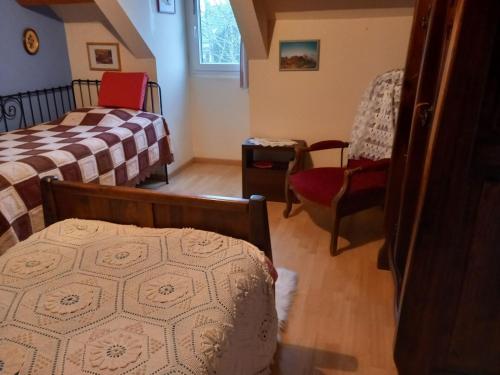 une petite chambre avec deux lits et une chaise dans l'établissement Chambres a louer pour JO PARIS 2024, à Chèvreville