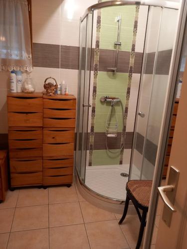 une douche avec une porte vitrée dans une salle de bain dans l'établissement Chambres a louer pour JO PARIS 2024, à Chèvreville