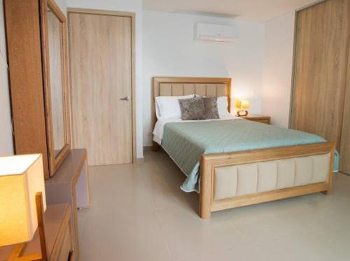 une chambre avec un lit, une commode et un miroir dans l'établissement Acogedor Apartamento Marbella ideal familias, à Carthagène des Indes