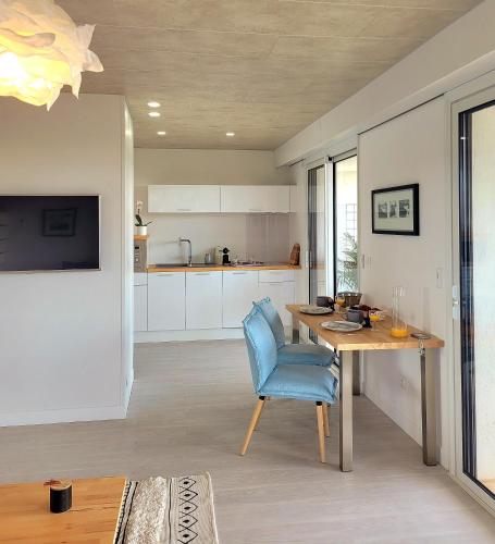 une cuisine avec une table et une chaise bleue dans l'établissement Studio climatisé, vue imprenable-wifi, à Vence