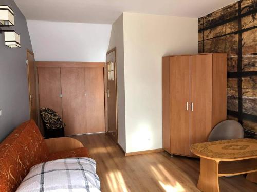 ein Schlafzimmer mit einem Bett und einem Tisch in einem Zimmer in der Unterkunft "Pokoje u Ireny"-pokój brzoza 4 osobowy in Sztutowo