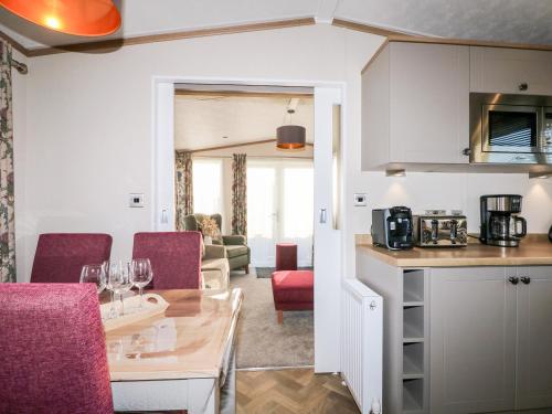 a kitchen and living room with a table and chairs at Chichester Lakeside Holiday Park in Chichester