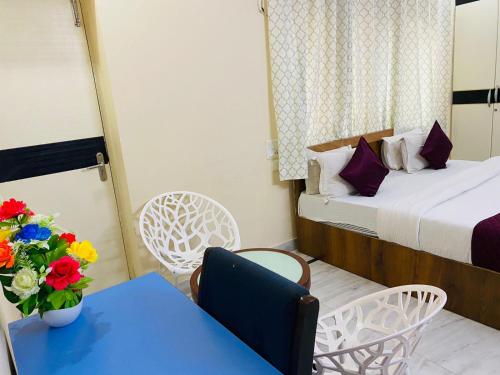 Habitación con cama, mesa y sillas. en KP Suites Gachibowli, en Hyderabad
