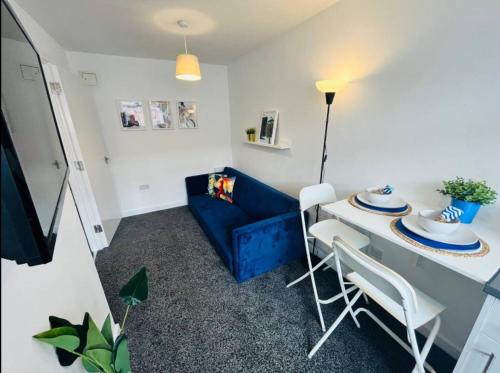 a living room with a blue couch and a table and chairs at Chic 1Bed Apt with Transport Links in Liverpool