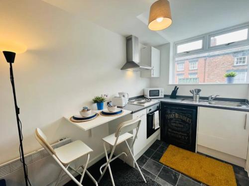 a kitchen with a table and chairs in a kitchen at Chic 1Bed Apt with Transport Links in Liverpool
