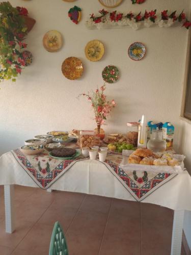een tafel met eten erop met borden aan de muur bij Vacanze Siciliane in San Vito lo Capo