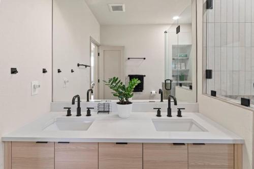 a white bathroom with two sinks and a potted plant at Unique Denver Designer Home 4 Bed 4 Bath in Denver