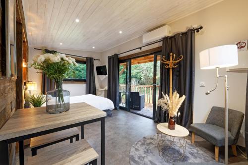 - une chambre avec un lit et une table ornée d'un vase de fleurs dans l'établissement Pied à Terre Autun, à Autun