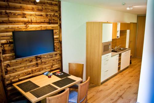 a dining room with a table and a television on a wall at Apartment Michael - Zell am See - Kaprun in Piesendorf