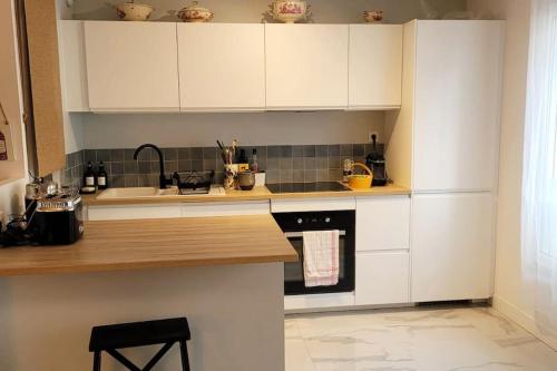 une cuisine avec des armoires blanches et un comptoir dans l'établissement L'élégant - Logement calme en ville - Chez Lulu, à Nantes