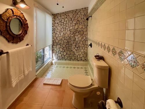 a bathroom with a toilet and a mirror at Rancho Las Cruces in Las Cruces