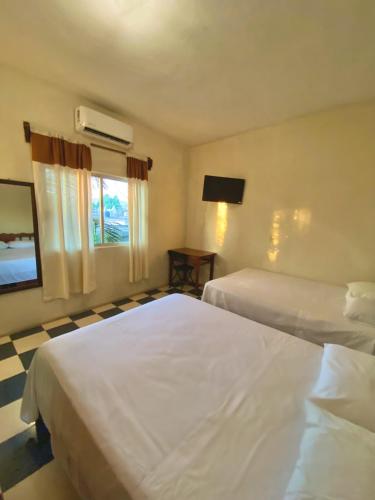 ein Hotelzimmer mit 2 Betten und einem TV in der Unterkunft Hotel Villa del Mar in Tonalá