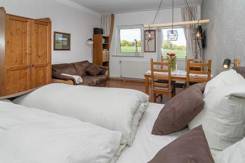 ein Wohnzimmer mit 2 Betten und ein Esszimmer in der Unterkunft Ferienhof Radlandsichten in Malente