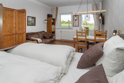 a living room with two beds and a dining room at Ferienhof Radlandsichten in Malente