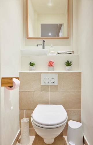 une salle de bain avec des toilettes blanches et un lavabo dans l'établissement Tour Eiffel & Champs Elysees - 2 BR gorgeous & bright 75m2 - free weekly housekeeping - for business and working purposes only, à Paris