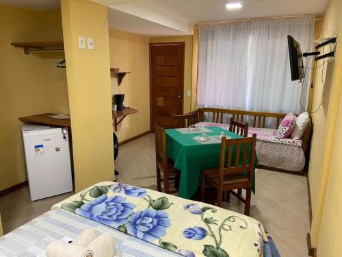 a room with a kitchen and a table with a green tablecloth at Estalagem O Italiano in Lumiar