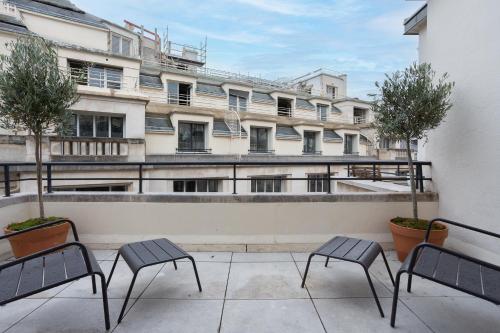 a balcony with two chairs and a building at Habitat Parisien - Bourse Feydeau in Paris