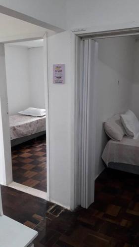 Habitación con 2 camas y puerta corredera de cristal en Casa da Lourdes 2 quartos, en Florianópolis