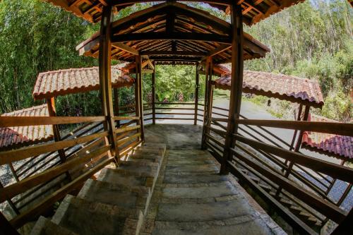 a wooden bridge over a river with trees at Vale Encantado - Eco Park & Hotel in Biritiba-Mirim
