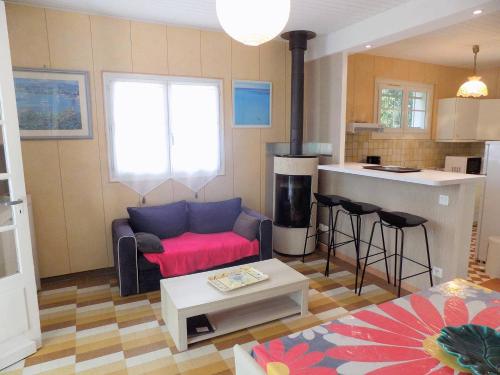een woonkamer met een bank en een keuken bij Saint Palais sur Mer - MAISON INDIVIDUELLE - Quartier du Platin in Saint-Palais-sur-Mer