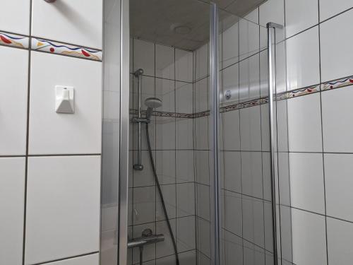 布爾邦萊班的住宿－Gîte Bourbonne-les-Bains, 2 pièces, 2 personnes - FR-1-611-99，浴室铺有白色瓷砖,设有淋浴。