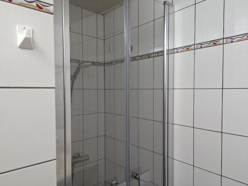 eine Dusche im Bad mit weißen Fliesen in der Unterkunft Gîte Bourbonne-les-Bains, 2 pièces, 2 personnes - FR-1-611-100 in Bourbonne-les-Bains