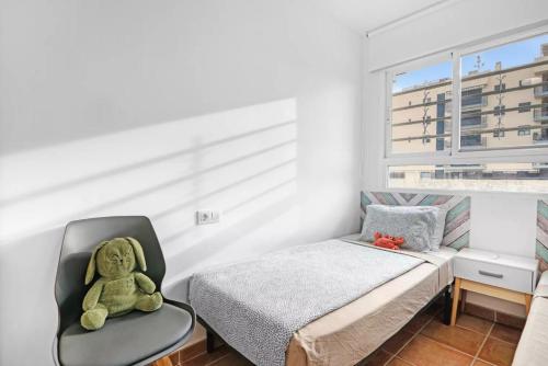 un osito de peluche sentado en una silla junto a una cama en Apartamento con PISCINA ideal FAMILIAS, en Chilches