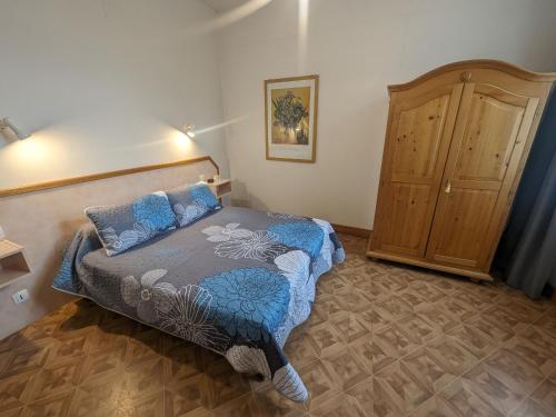 1 dormitorio con 1 cama y armario de madera en Gîte Bourbonne-les-Bains, 2 pièces, 2 personnes - FR-1-611-97, en Bourbonne-les-Bains