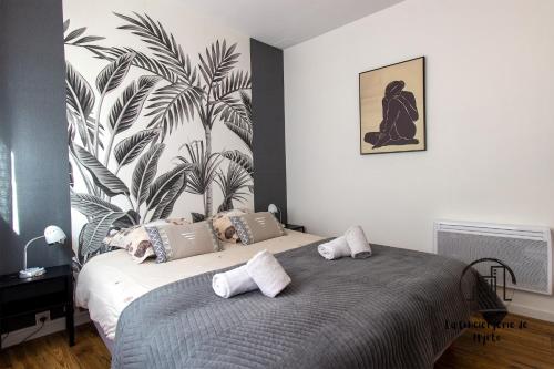 a bedroom with a bed with a plant on the wall at Au cœur des Lices in Albi