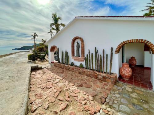 a white house with cactus in front of it at Rancho Las Cruces in Las Cruces
