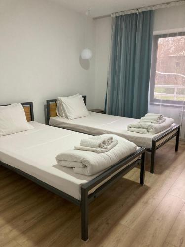 drie bedden in een kamer met een raam bij TOURIST HOTEL in Simkent