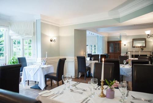 a dining room with tables and chairs and tablesearcher at Findon Manor Hotel in Worthing