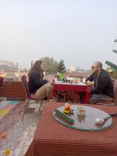 een groep mensen die aan een tafel op een dak zitten bij Shiva guest House (hoche poche cafe ) in Agra