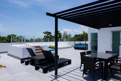 a patio with a table and chairs on a roof at The Fives Beach Hotel & Residences - All Senses Inclusive in Playa del Carmen