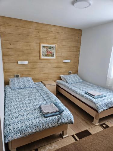 2 Einzelbetten in einem Zimmer mit gedankenlosem, gedankenlosem, gedankenlosem, gedankenlosem in der Unterkunft Ruža vetrova in Kušići