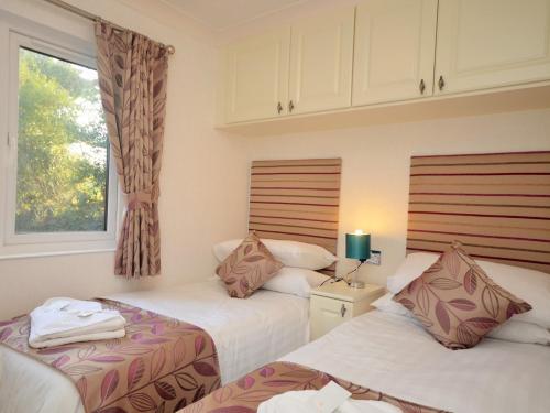 two beds in a small room with a window at 3 Bed in Okehampton 49134 in Okehampton