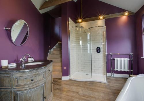 a purple bathroom with a sink and a shower at Orchard Cottage in Newlyn