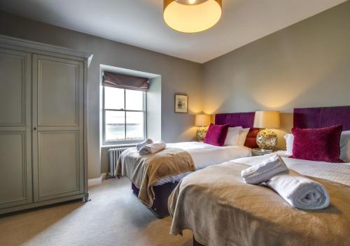 a bedroom with two beds and a window at Orchard Cottage in Newlyn