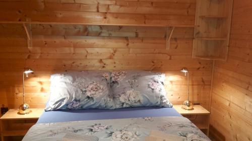 ein Schlafzimmer mit einem Bett mit einer Holzwand in der Unterkunft Agroturystyka Polana Harmonii in Przytoczna 